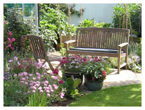 A small sandstone patio provides seating amongst the flowers.  Garden design in Bedfordshire