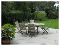 Raised patio with view over lawn and planting.