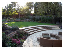 Large sheltered sunken patio with views of the upper garden.  Harpenden garden design in autumn.